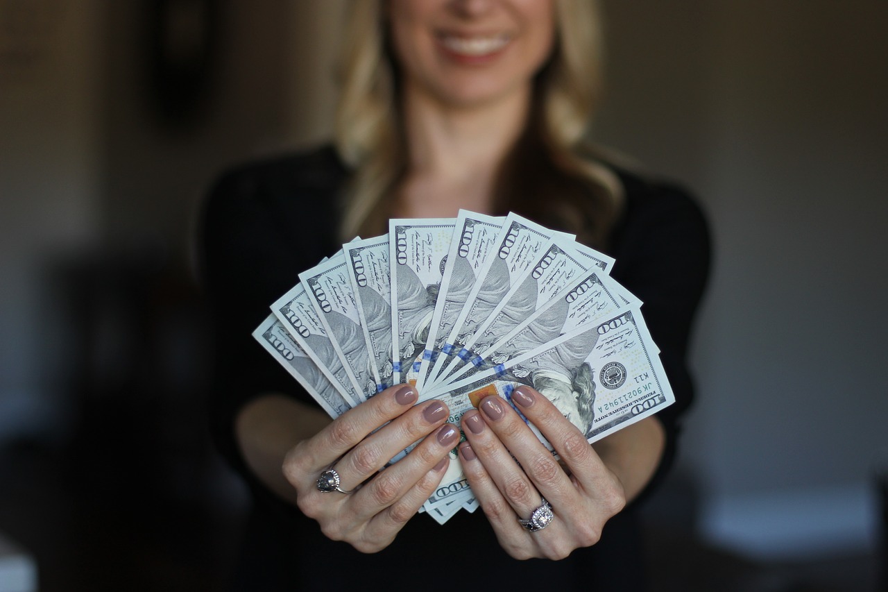 A woman holding a large amount of cash.